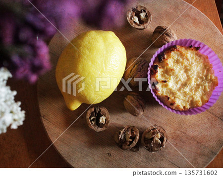 A home-baked tart with lemon and walnuts on a round wooden board. Candid, cozy scene is perfect for food and lifestyle content. Rustic food. 135731602