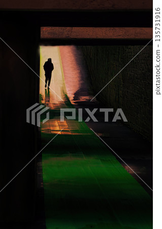 人們走過一條形似光隧道的地下通道 人們走過一條形似光隧道的地下通道 135731916