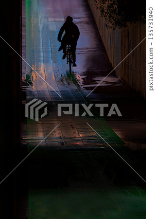 一名男子騎著自行車穿過地下通道。 135731940