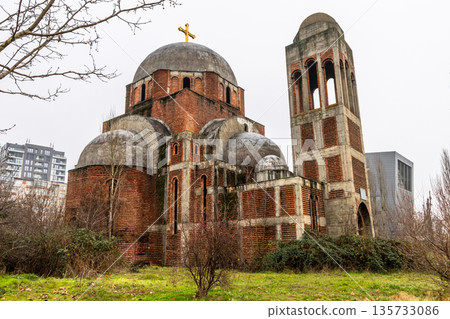 Abandoned unfinished ruined Serbian orthodox church with brick walls, weathered dome and christian cross standing empty in urban landscape, Pristina, Kosovo Abandoned unfinished ruined Serbian orthodox church with brick walls, weathered dome and christian cross standing empty in urban landscape, Pristina, Kosovo 135733086