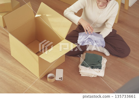Young woman packing her belongings for moving 135733661