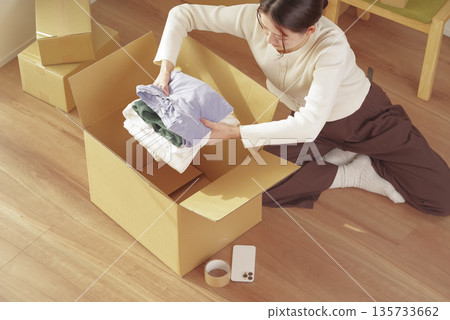 Young woman packing her belongings for moving 135733662