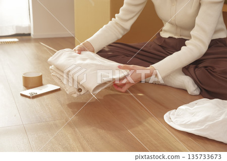 年輕女子正在收拾行李準備搬家 年輕女子正在收拾行李準備搬家 135733673