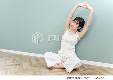 Asian woman stretching and taking deep breaths at home (exercise, fitness) 135733900