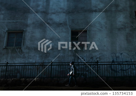 人們經過一座廢棄的建築物 人們經過一座廢棄的建築物 135734153