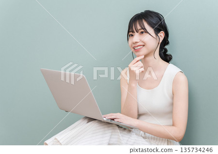 Young Asian woman smiling and thinking using a computer at home (fun, imagination, conception, planning, plan) Young Asian woman smiling and thinking using a computer at home (fun, imagination, conception, planning, plan) 135734246