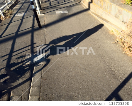 自行車和人的輪廓投射到瀝青路面上 135735298
