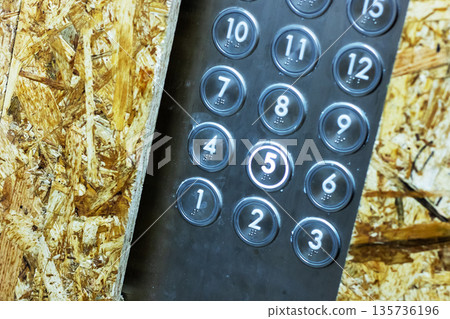 Detailed shot of rugged industrial keypad with circular buttons on weathered wooden panel Detailed shot of rugged industrial keypad with circular buttons on weathered wooden panel 135736196