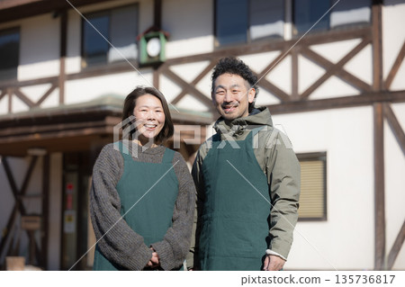 Image of a couple running a family-run inn, pension, and cafe in the countryside, looking at the camera 135736817