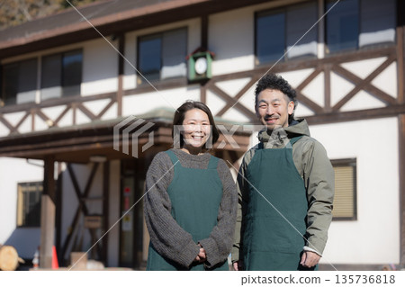 Image of a couple running a family-run inn, pension, and cafe in the countryside, looking at the camera 135736818