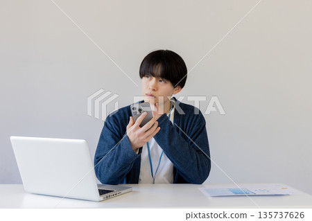 A businessman worried while using a smartphone 135737626