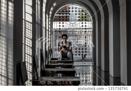 Snapshot photo woman with her camera at inside the Loha Prasart Metal Palace at Ratchanaddaram temple. Snapshot photo woman with her camera at inside the Loha Prasart Metal Palace at Ratchanaddaram temple. 135738791
