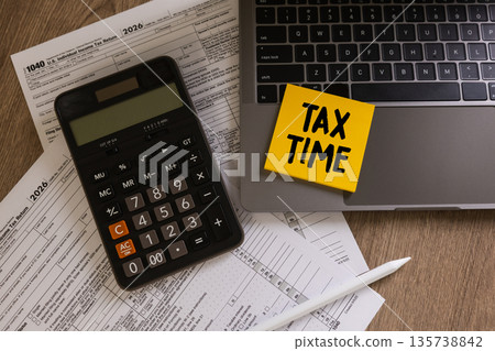 Tax time concept US Individual income tax return planning calculating income calculator, laptop, preparing to file and reduce liability. 135738842