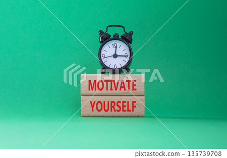 Motivation symbol. Concept words Motivate yourself on wooden blocks. Beautiful green background with alarm clock. Business and Motivate yourself concept. Copy space. 135739708