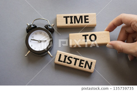 Time to listen symbol. Concept words Time to listen on wooden blocks. Businessman hand. Beautiful grey background with alarm clock. Business and Time to listen concept. Copy space. Time to listen symbol. Concept words Time to listen on wooden blocks. Businessman hand. Beautiful grey background with alarm clock. Business and Time to listen concept. Copy space. 135739735