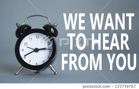 We want to hear from you symbol. Wooden blocks with words We want to hear from you. Beautiful grey background with alarm clock. Business and We want to hear from you. Copy space. 135739767