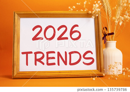 2026 Trends symbol. Concept words 2026 Trends on beautiful wooden picture frame. Beautiful orange background with flower vase. Business and 2026 Trends concept. Copy space. 2026 Trends symbol. Concept words 2026 Trends on beautiful wooden picture frame. Beautiful orange background with flower vase. Business and 2026 Trends concept. Copy space. 135739786
