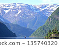 A fjord sightseeing boat heading to Hardangerfjord surrounded by towering mountains 135740320