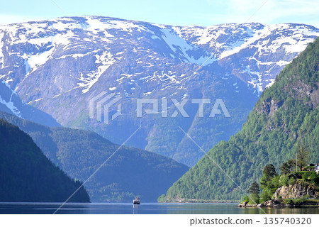 一艘峽灣觀光船正駛向哈當厄爾峽灣，四周環繞著巍峨的山脈。 135740320