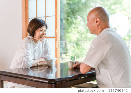 一對老年夫婦在日式房間裡喝茶,房間外是鬱鬱蔥蔥的綠植(下午茶時間,旅館,日式房間,客廳) 一對老年夫婦在日式房間裡喝茶,房間外是鬱鬱蔥蔥的綠植(下午茶時間,旅館,日式房間,客廳) 135740541