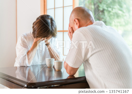 Senior couple holding their heads in shock in a Japanese-style room at home (crying, middle-aged divorce, trouble) 135741167