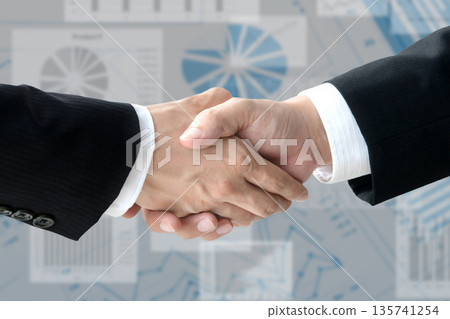 商人的雙手在商業圖表的背景下握手 商人的雙手在商業圖表的背景下握手 135741254