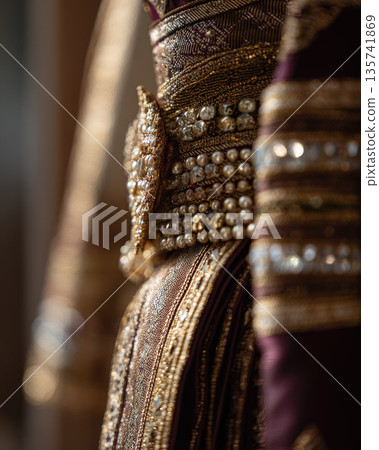 Traditional Thai wedding dress adorned with intricate gold embroidery and pearl details creates elegant and luxurious cultural fashion statement 135741869