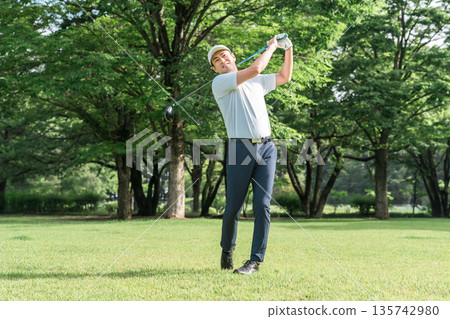 A golfer's man playing golf on a golf course (tee shot/golf competition) A golfer's man playing golf on a golf course (tee shot/golf competition) 135742980