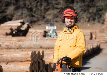 Forestry worker with chainsaw, primary industry image, smiling, looking at camera 135744583