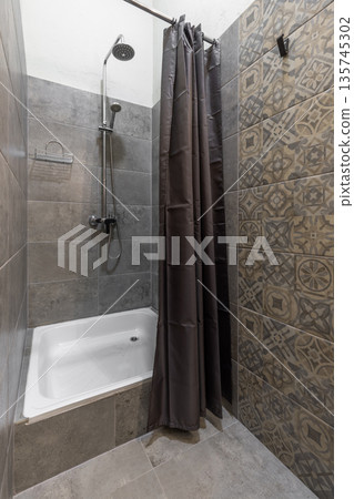 Modern hostel shower cabin with grey stone and patterned tiles Modern hostel shower cabin with grey stone and patterned tiles 135745302
