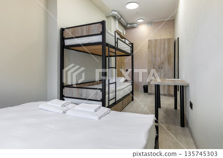 Hostel dormitory with industrial bunk bed and minimalist desk 135745303
