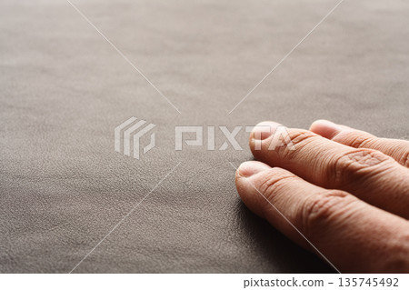 Closeup man hand check dark brown full grain leather 135745492