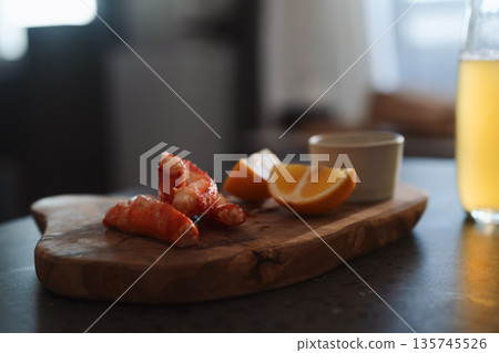 Crab legs with lemon and dressing on olive woob board Crab legs with lemon and dressing on olive woob board 135745526