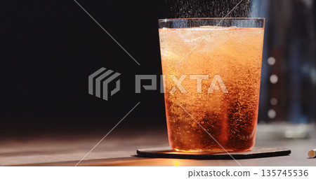 pour syrup in tonic in tumbler glass on walnut table 135745536