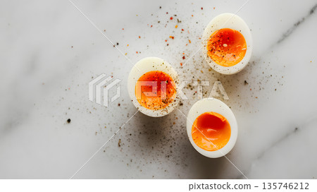 Three deviled eggs garnished with paprika on marble surface 135746212