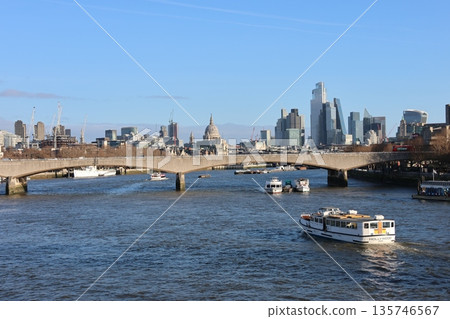 A bridge spans a river in a city with a view of the city skyline 135746567