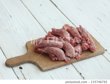 Raw fresh chicken necks on a cutting board. Raw fresh chicken necks on a cutting board. 135746785