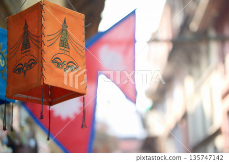 Orange lanterns with Buddha eyes painted on them and the cityscape of Nepal Orange lanterns with Buddha eyes painted on them and the cityscape of Nepal 135747142