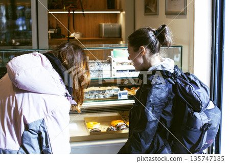 two girl friends having fun with street food in europe, lifestyle people concept two girl friends having fun with street food in europe, lifestyle people concept 135747185
