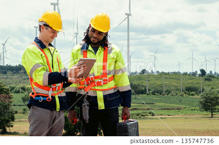 Two men in safety gear are looking at a tablet Two men in safety gear are looking at a tablet 135747736