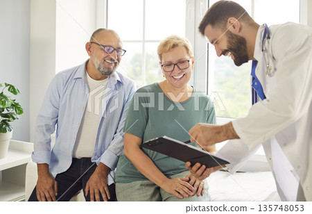 Smiling senior couple consulting with friendly doctor about test results and care Smiling senior couple consulting with friendly doctor about test results and care 135748053