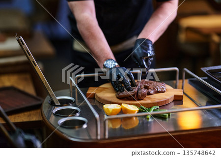 Chef Slicing Tender Beef Steak On Cutting Board In Professional Kitchen For Dinner Chef Slicing Tender Beef Steak On Cutting Board In Professional Kitchen For Dinner 135748642