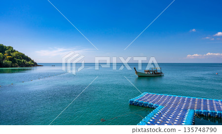 Beautiful coastal views of Koh Samed island featuring speedboats, traditional long-tail boats, and a floating pier on turquoise waters Beautiful coastal views of Koh Samed island featuring speedboats, traditional long-tail boats, and a floating pier on turquoise waters 135748790