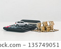 Miniature silver car on a calculator beside stacked coins on a white background, illustrating car cost calculation, down payment savings, auto loan budgeting and financial planning for purchase. 135749051