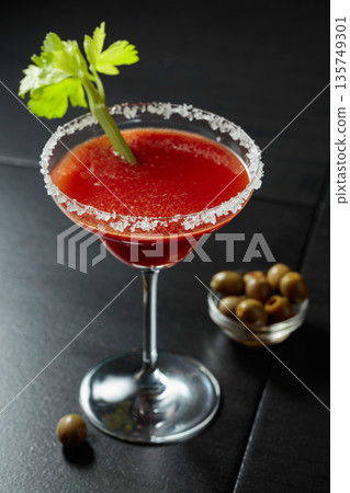 Bloody Mary cocktail with celery and green olives. 135749301