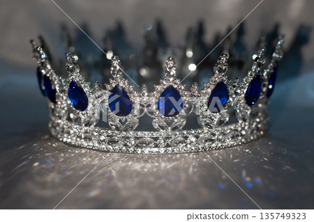 Sapphire white golden crown on grey background. Blue gemstones. Sapphire white golden crown on grey background. Blue gemstones. 135749323