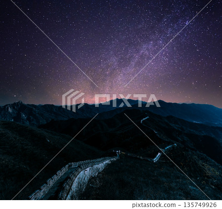 Great Wall of China winding through mountains under starry Milky Way night sky 135749926