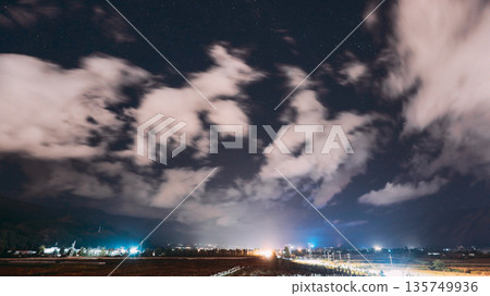 Night clouds and stars over Lijiang valley lights 135749936