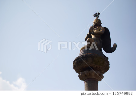 尼泊爾一座寺廟裡，神靈在石柱上祈禱的金像 135749992