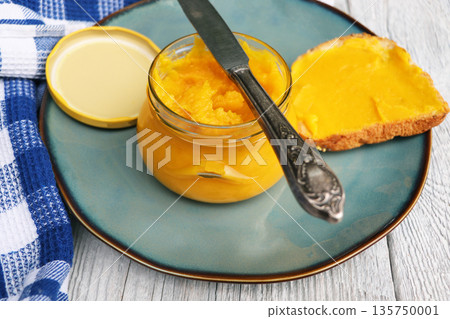 Homemade pumpkin butter in glass jar made with organic pumpkins Homemade pumpkin butter in glass jar made with organic pumpkins 135750001
